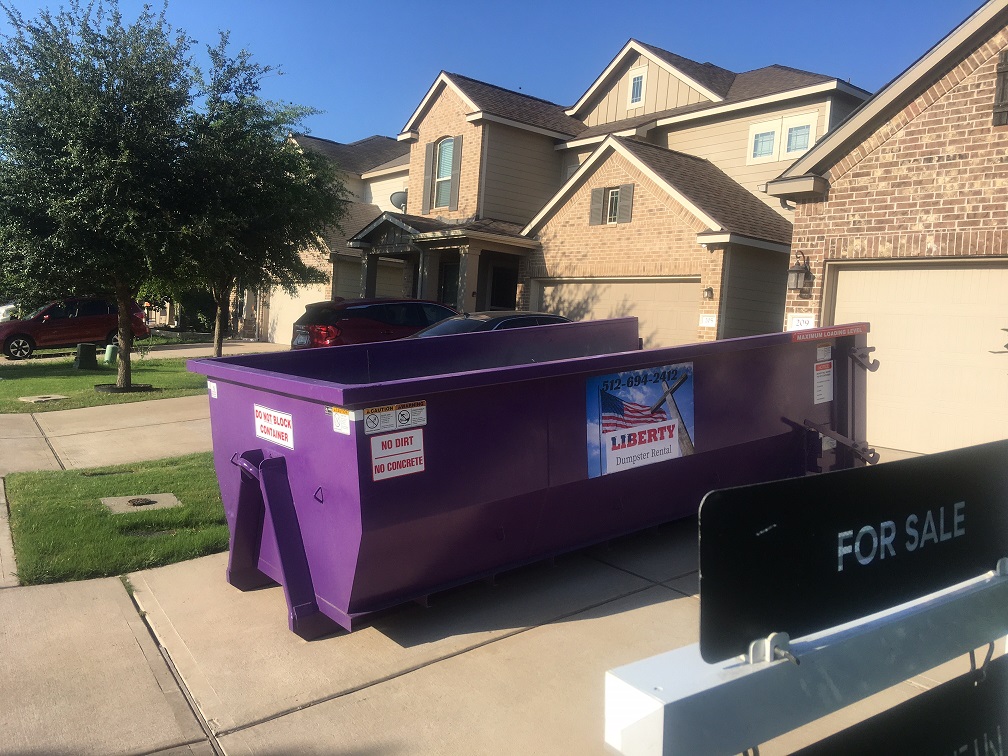 Purple Liberty dumpster placed in a driveway in Cedar Park, TX